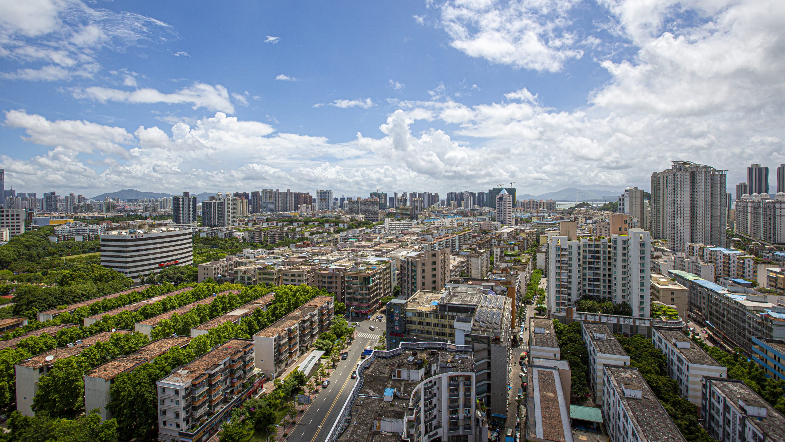 Cityscape of Shenzhen, China, during a sunny afternoon with white clouds, looking over the residential area. Photographer Tuomas Harjumaaskola.