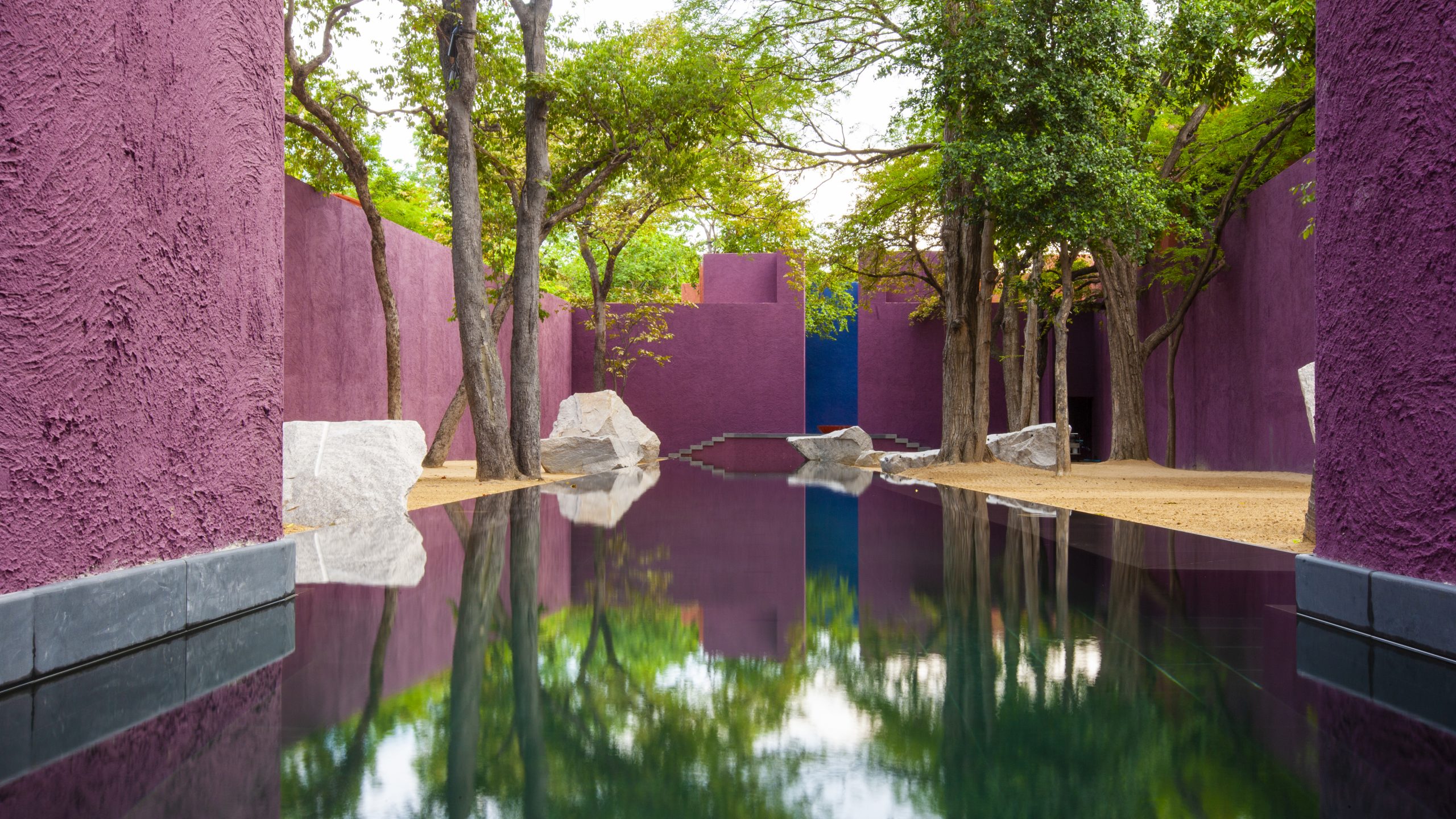 Architectural photography of a meditation and holiday retreat with a swimming pool and magenta color walls. Photographer Tuomas Harjumaaskola.