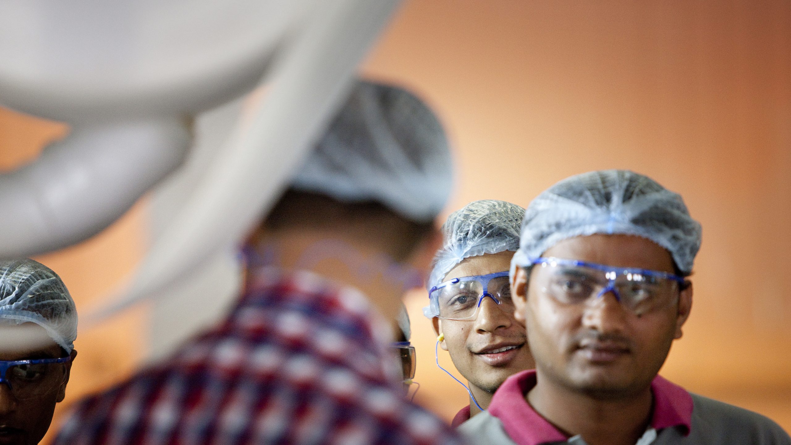 Indian factory workers listening to instructions. Photographer Tuomas Harjumaaskola.