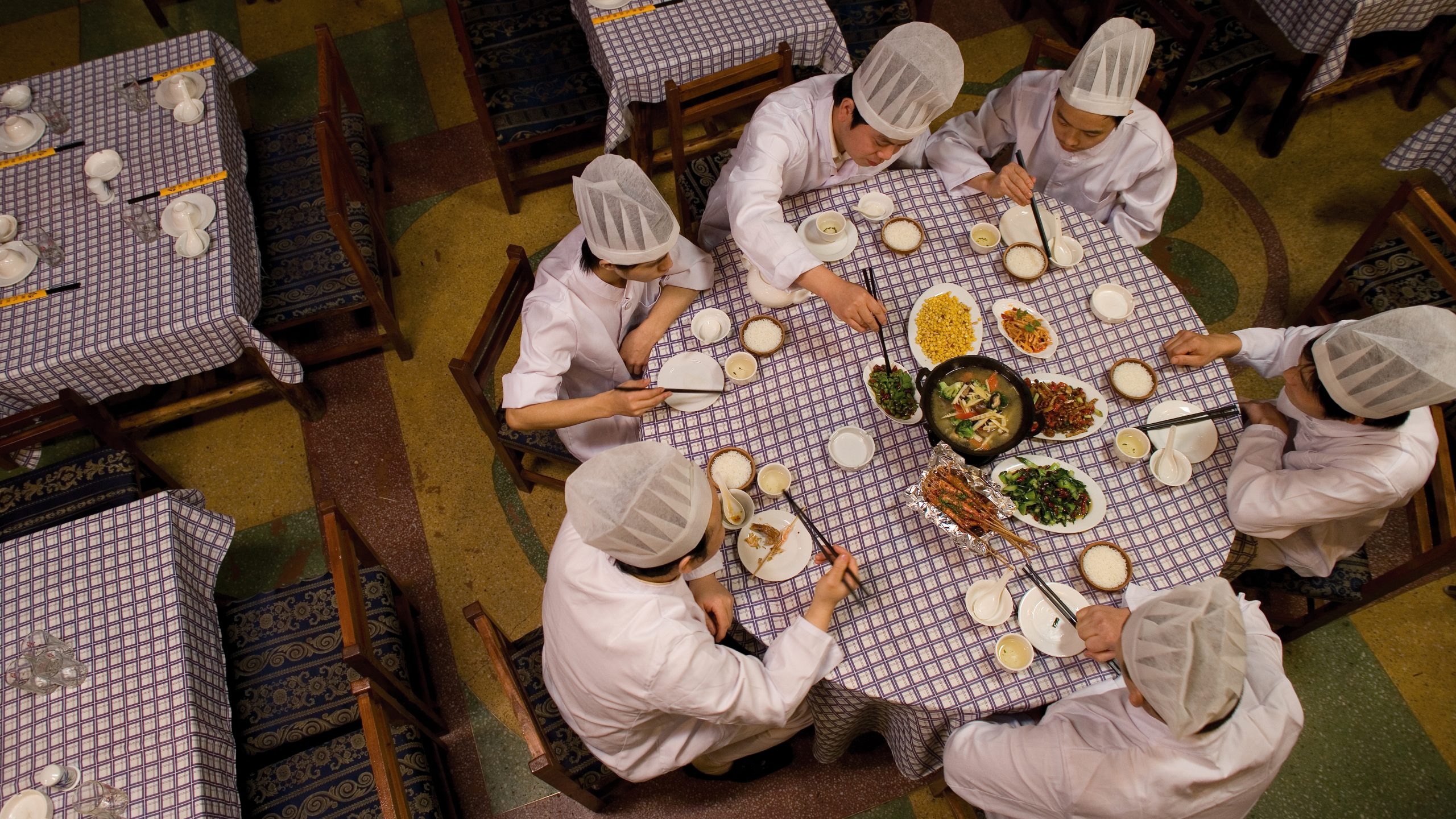 Chinese chefs having lunch together around a round table. Photographer Tuomas Harjumaaskola.