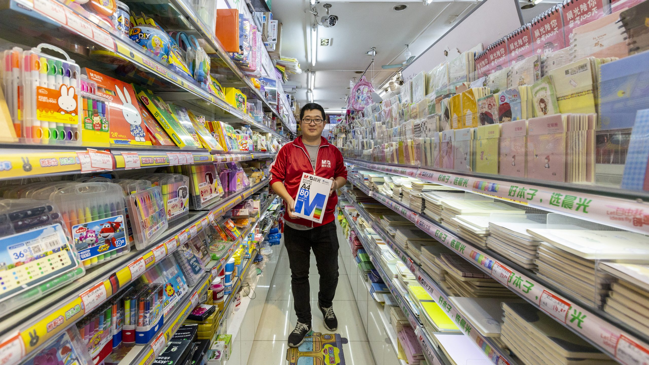 Salesperson displaying copy paper in a stationary store in Shanghai - photo by photographer Tuomas Harjumaaskola, China