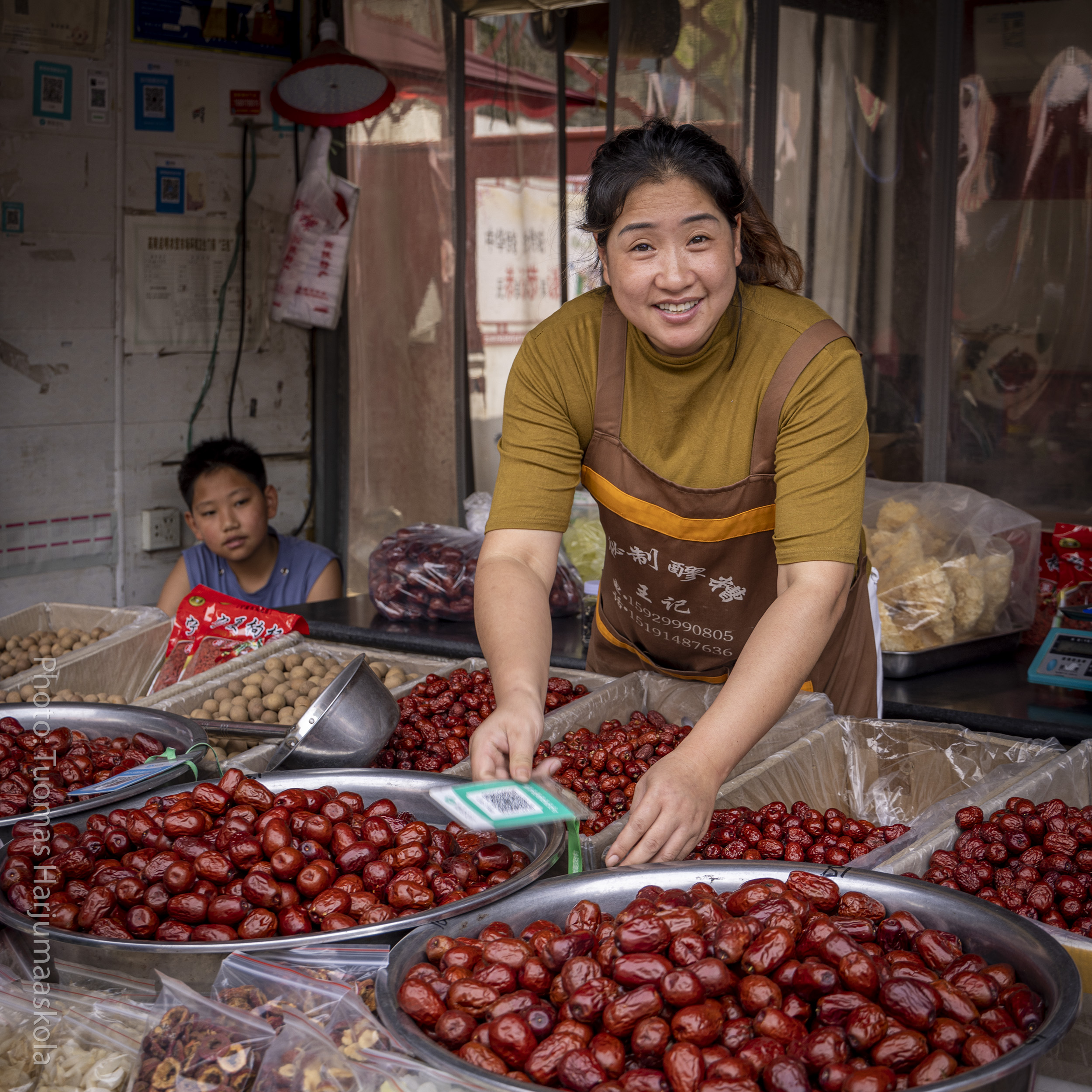 Chinese lady selling Chinese dates, jujubes, at a food market. Photographer by Tuomas Harjumaaskola.